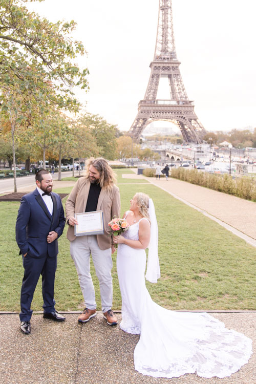 bilingual officiant in Paris with newly weds holding wedding certificate at the Eiffel Tower